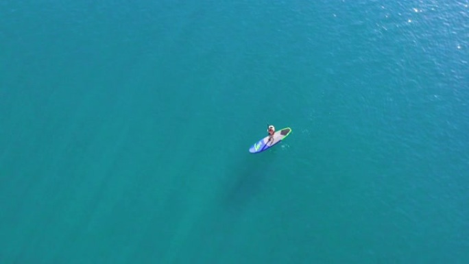 空中俯瞰海洋中的划桨板女人