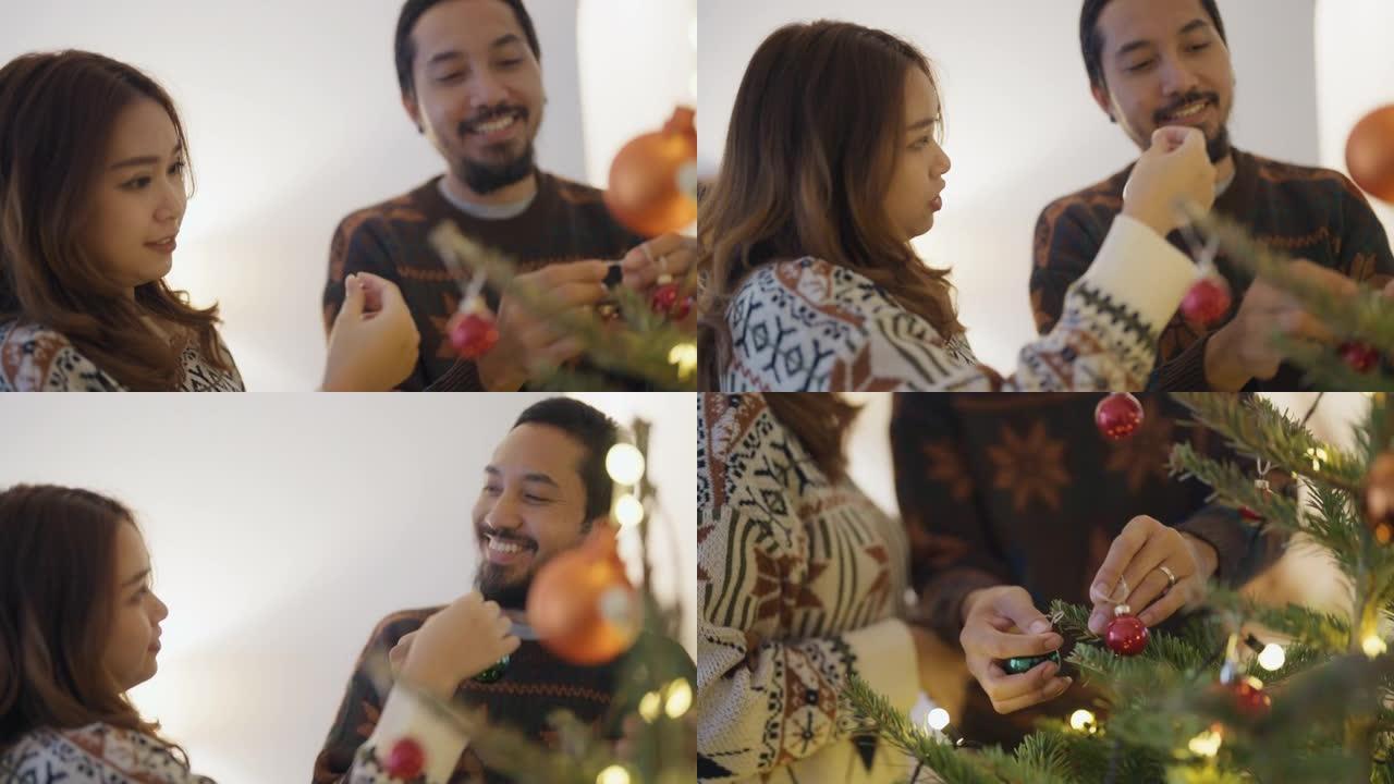 亚洲夫妇正在家里装饰圣诞树。
