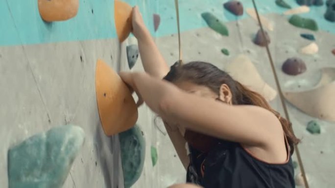 女孩在攀岩馆攀爬的特写镜头，慢动作