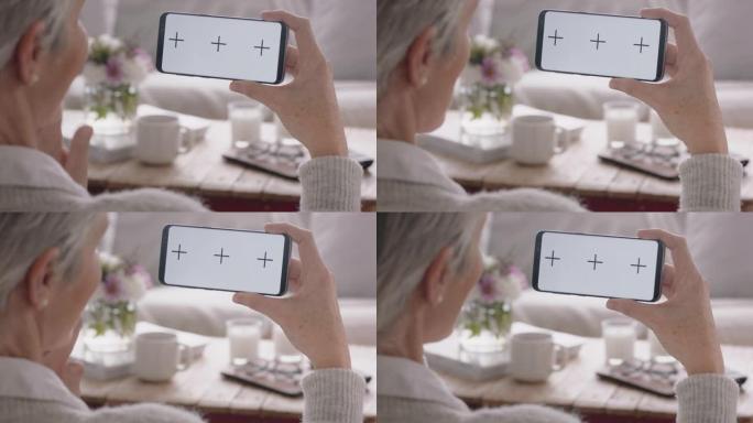 成熟的女人使用智能手机进行视频聊天绿屏祖母聊天看着色键享受水平方向的手机复合显示器4k镜头
