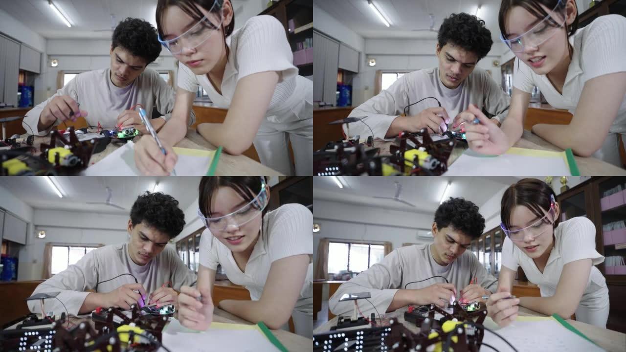 两个青少年为项目学习和分析机器人工程