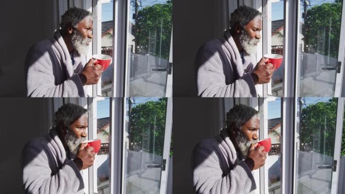 老人在家里看着窗外时喝咖啡