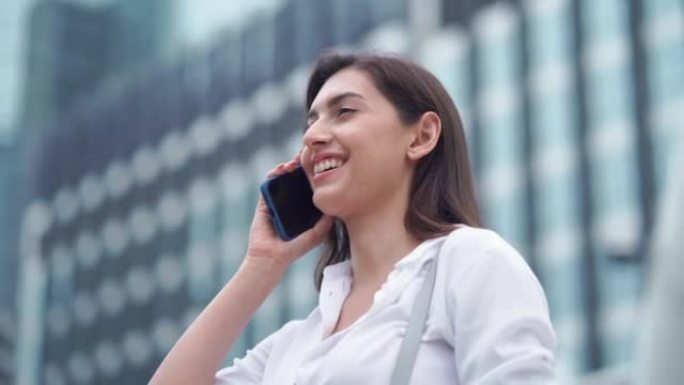 在现代城市中，女商人使用电话与幸福