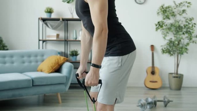 现代室内男性手的慢动作特写和带伸缩带的身体训练
