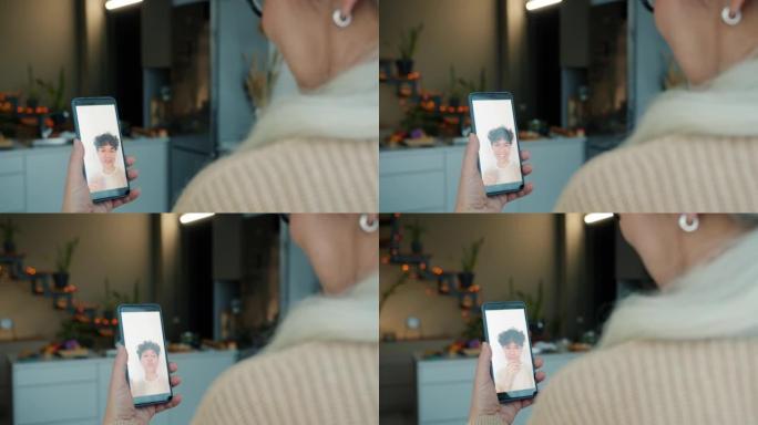 成熟女士的肖像与女儿年轻女子用智能手机进行视频通话