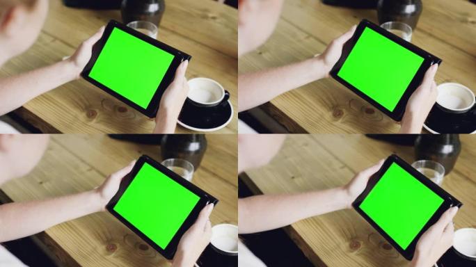 4k视频片段，一个无法识别的女人独自坐在咖啡馆里并使用数字平板电脑