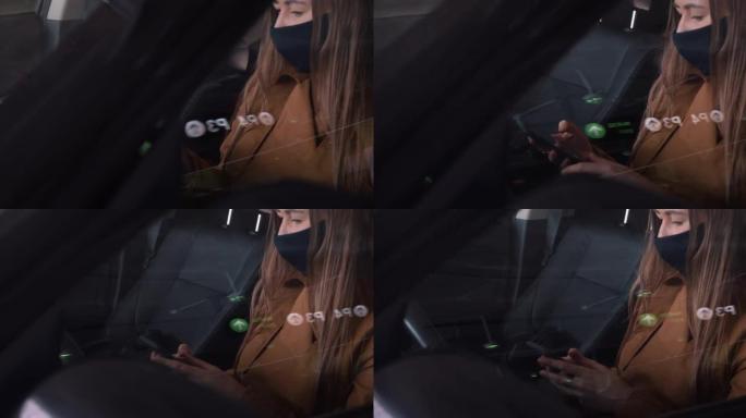 使用智能手机坐在停车场的汽车驾驶员座位上拍摄的年轻快乐美丽的女人戴着口罩的电影照片。