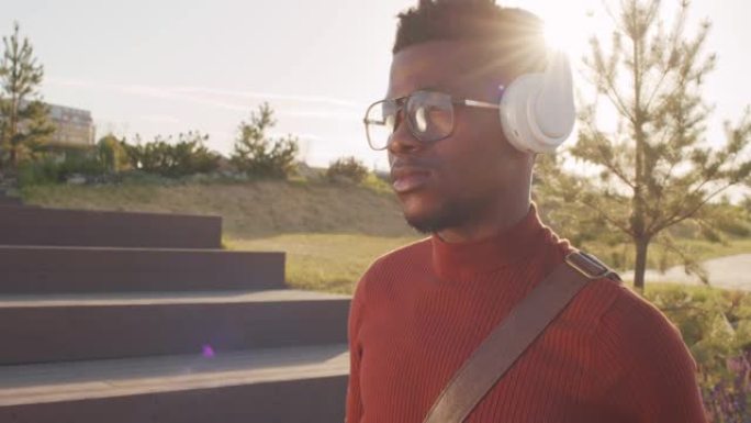 年轻的黑人在户外享受耳机音乐