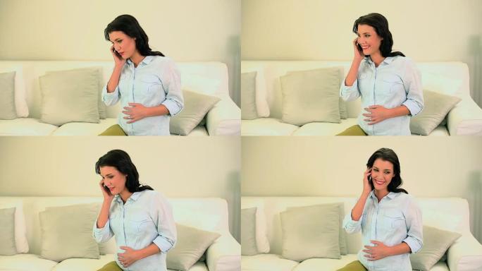 美丽的怀孕黑发女人在电话里聊天