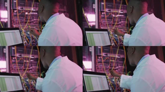 非裔美国男性计算机技术员使用笔记本电脑在商务服务器机房工作
