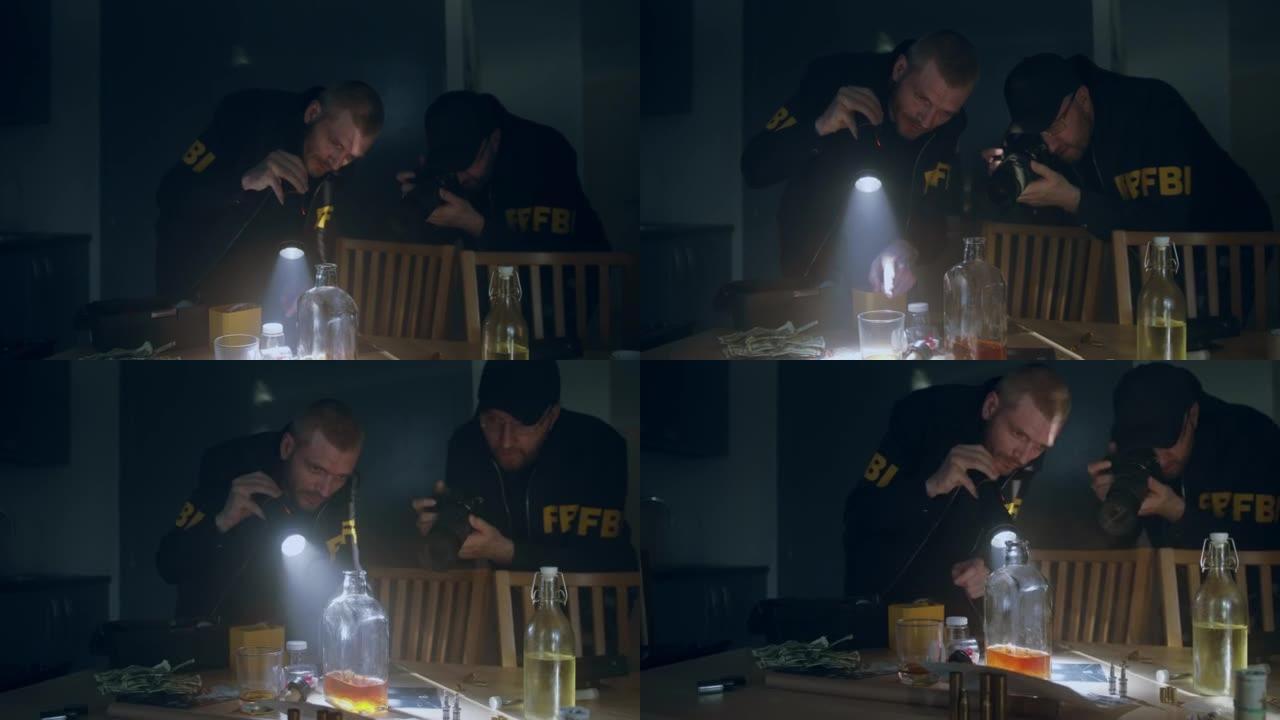 在一间暗室里，两名身穿制服的白人联邦调查局探员拿着手电筒和照相机，在桌子上检查物证。那张桌子上有一堆