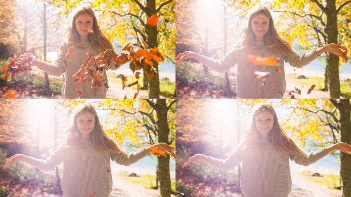 微笑的年轻女子向空中扔秋叶