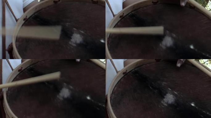 男子演奏典型的 “bomboleg ü ero”，这是阿根廷用木头和动物皮革制成的低音鼓。特写。