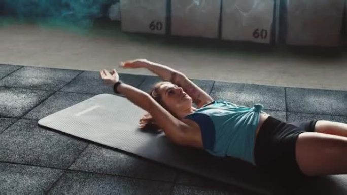 意志力和强烈的精神理念。迷人的运动年轻女子在大气光健身房的瑜伽垫上锻炼。