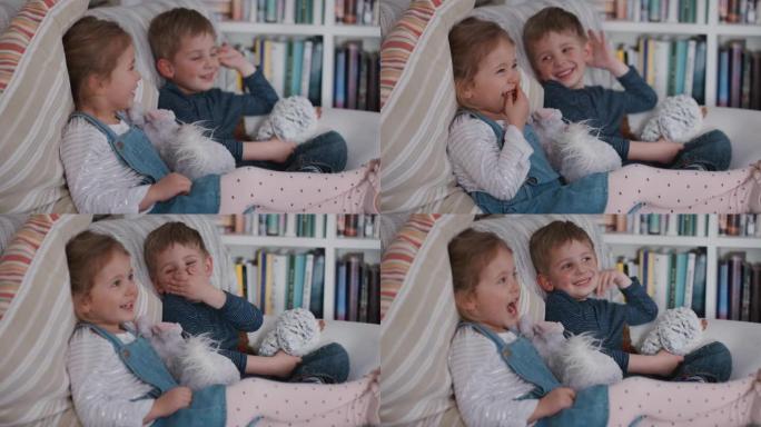 有趣的小男孩和女孩坐在家里的沙发上哥哥和姐姐开玩笑开玩笑傻4k