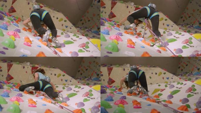 自下而上: 女孩在室内铅攀爬时将绳索绑在登山扣中