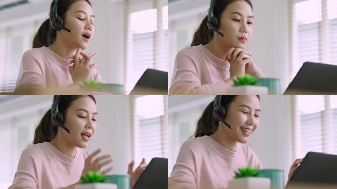 亚洲女性在家戴无线耳机工作视频通话