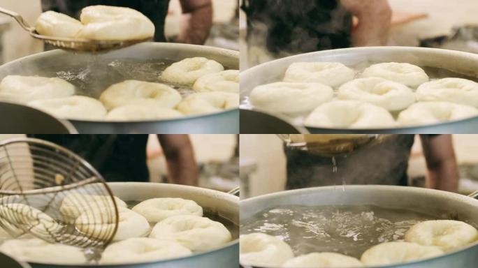 4k视频片段，一个无法识别的面包师在面包店从锅中取出百吉饼