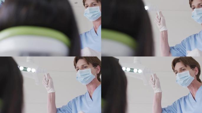 在现代牙科诊所为女性患者准备面具的高加索女性牙医