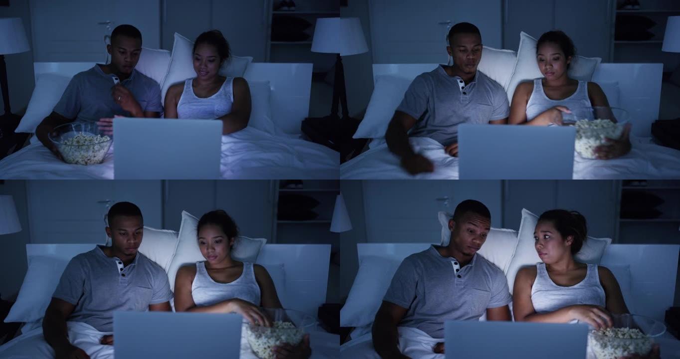 4k视频片段，一对年轻有魅力的夫妇在家里床上的笔记本电脑上看电影