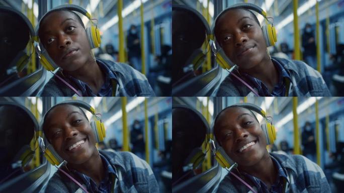 年轻女子微笑着，戴着耳机听音乐，晚上透过火车的窗户看。一名勤奋的员工乘坐公共交通工具回家的工作日结束