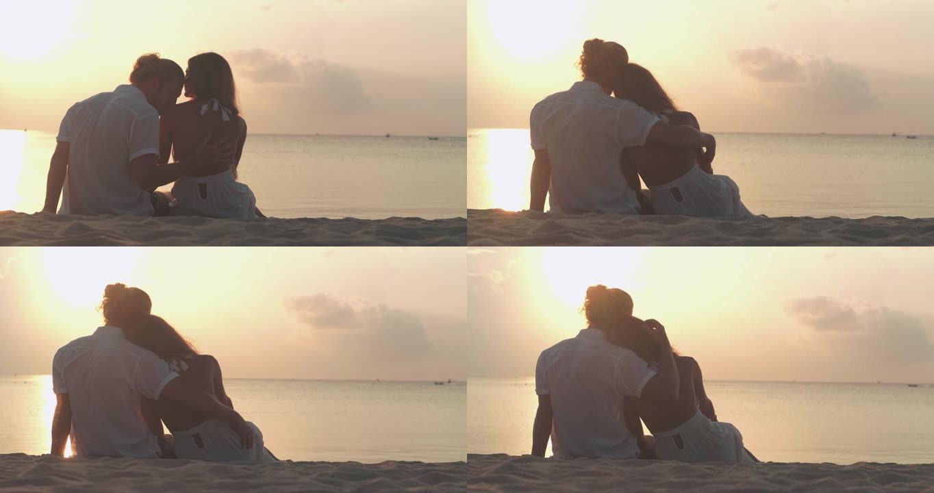 拉丁美洲和西班牙裔25-29岁夫妇的剪影，在沙滩上沿着日落海的边缘浪漫。假期-iStock概念。