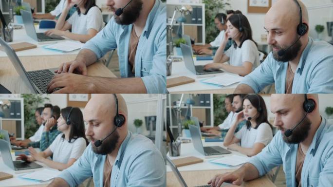 男性客户服务专家在现代办公室使用笔记本电脑说话和打字