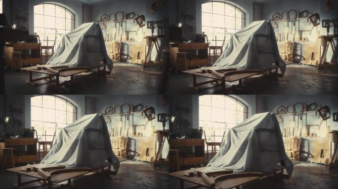 建立镜头: 在木工车间正式展示之前，隐藏在面纱下的设计师椅子。放大布套下时尚扶手椅的照片。