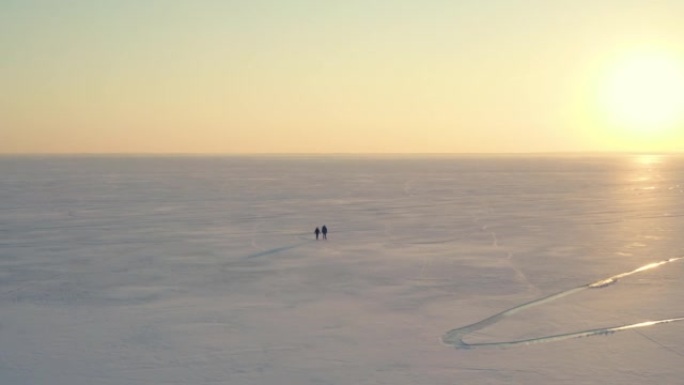 男人和女人走过冰冷的雪原