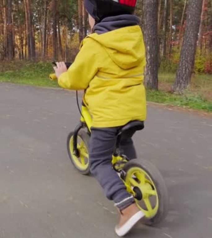 男孩骑平衡自行车的垂直镜头