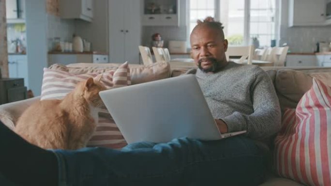 一个成熟男人在家中使用笔记本电脑的4k视频片段