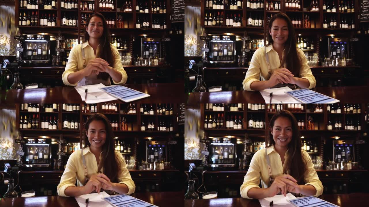 快乐的女业务经理在酒吧做会计时微笑着看着相机微笑