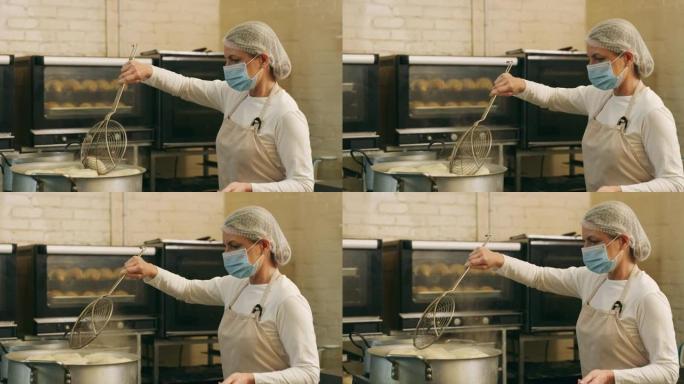 一个成熟的女性面包师在面包店的锅中煎炸百吉饼的4k视频片段