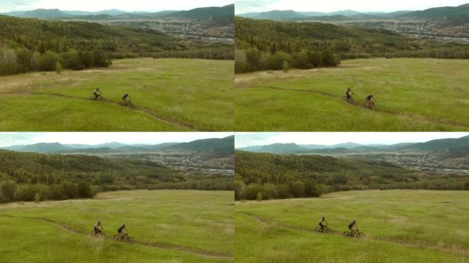 两个人骑自行车的鸟瞰图，日落时分的山地自行车步道