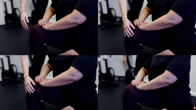 一名妇女在健身工作室与教练一起进行伸展运动的特写镜头