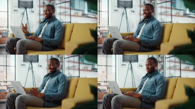 英俊的黑人非洲裔美国男子坐在客厅的沙发上，在笔记本电脑上进行视频通话。自由职业者在家工作，通过互联网