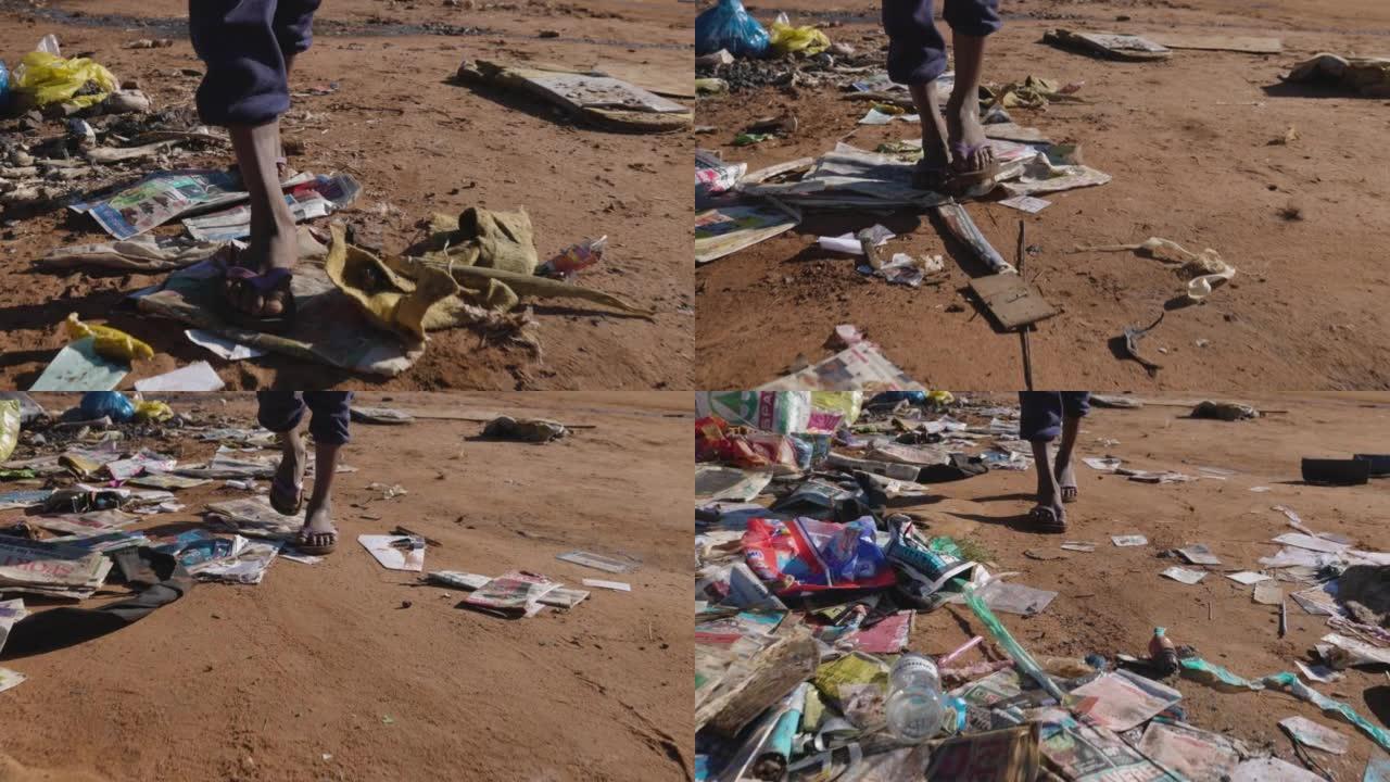 贫穷。污染。非洲黑人男孩在小镇贫民窟里穿过一堆垃圾的短视