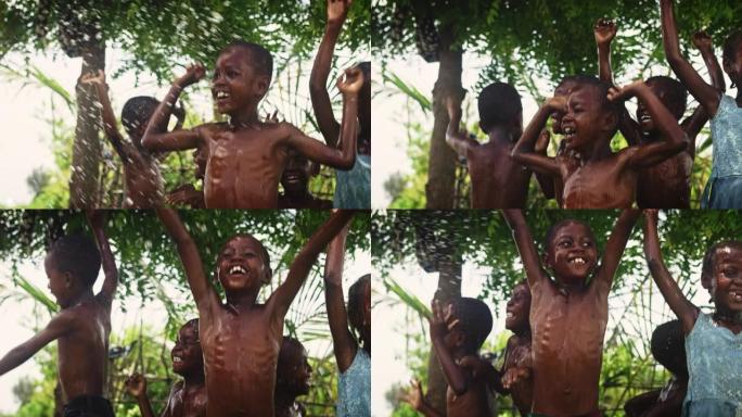 一群非洲孩子在被泼水时又跳又笑。快乐而天真的黑人孩子在长时间干旱后玩耍和享受雨水的祝福