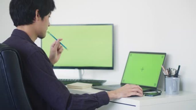 年轻人坐在现代公司的办公室里，使用电脑。