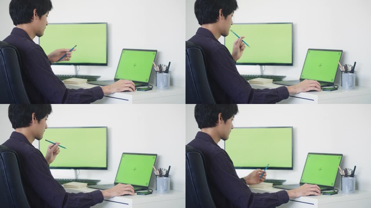 年轻人坐在现代公司的办公室里，使用电脑。