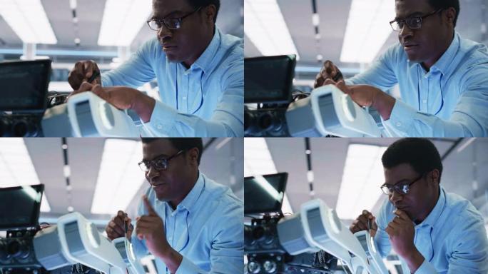 一位非洲裔美国机器人工程师用螺丝刀固定螺栓的特写肖像设置了一个机器狗原型。科学家将主板连接到移动AI