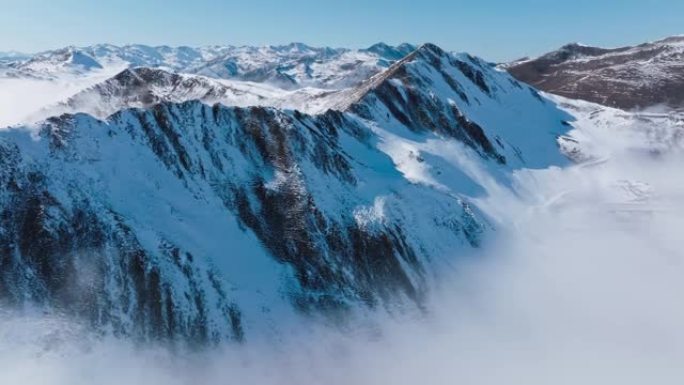 中国四川夹金山山谷中浮有雾云的空中雪山景观