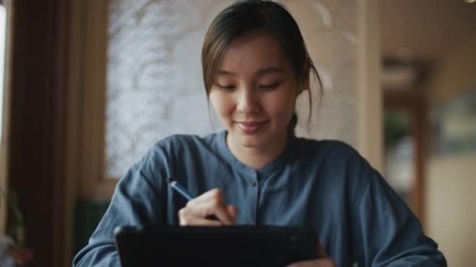 亚洲妇女在咖啡店使用数字平板电脑