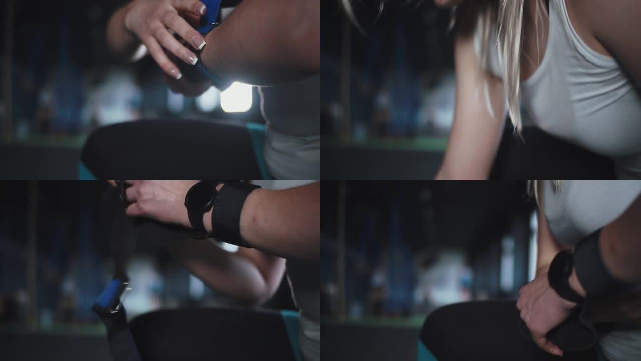 带智能手表的特写女健身房运动员将保护性腕带放在准备在健身房锻炼的手上。