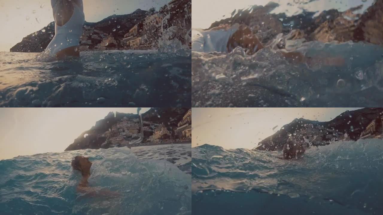欣喜若狂的女人在著名村庄波西塔诺的海湾游泳