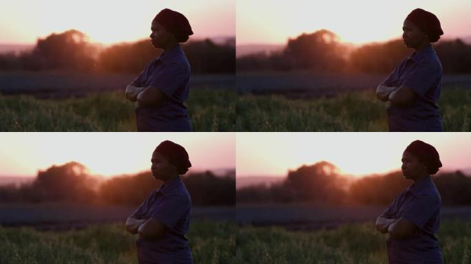 日落时站在农田里的非洲黑人女农民的特写侧面肖像