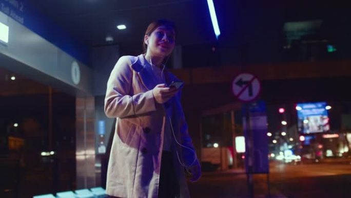 女人在公交车站使用智能手机