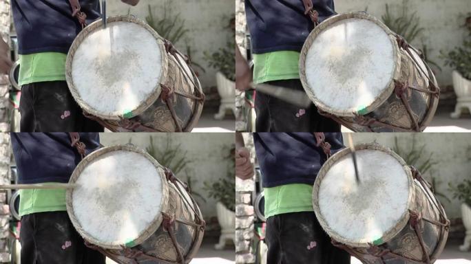 男子演奏典型的 “bomboleg ü ero”，这是一种用木头和动物皮革制成的低音鼓，用于阿根廷当