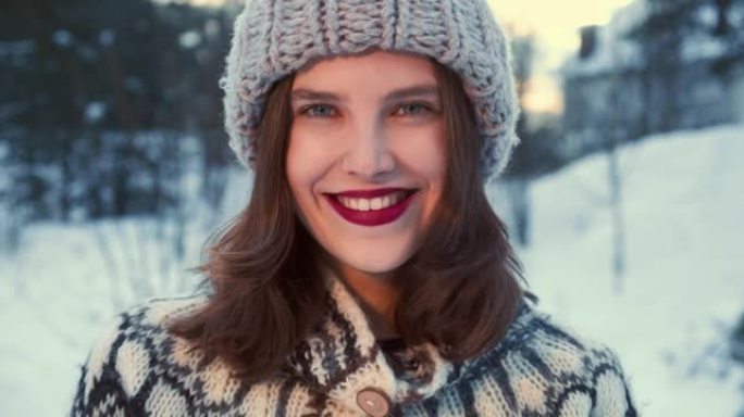 冬季季节。美丽年轻快乐的20多岁学生女子在白雪皑皑的森林慢动作中对着镜头微笑的肖像。