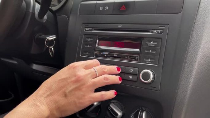 女性手在车里调音收音机。特写。4k分辨率。